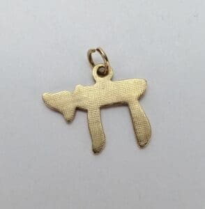Gold Chai pendant on white background.