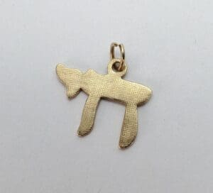 Gold pendant in Hebrew letter shape.