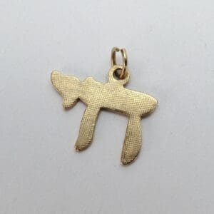Gold pendant in Hebrew letter shape.