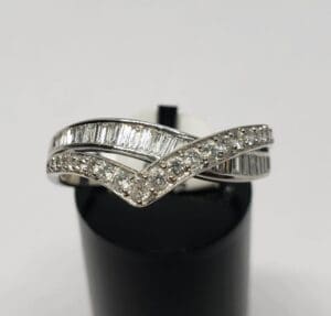Diamond-studded silver ring on display stand.