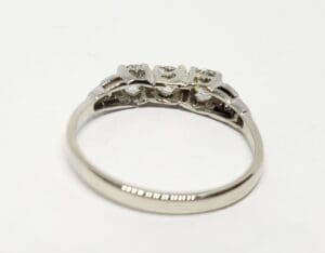 Silver ring with three diamond settings.