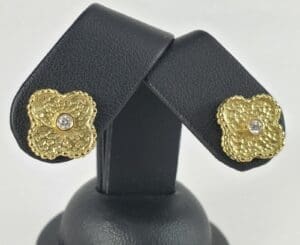 Gold floral earrings with central diamonds.