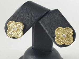 Gold flower earrings with diamond centers.