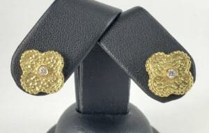 Gold textured earrings with central gemstones.