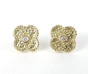 Gold flower earrings with central diamonds.