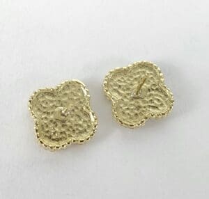 Gold flower-shaped button covers on display.