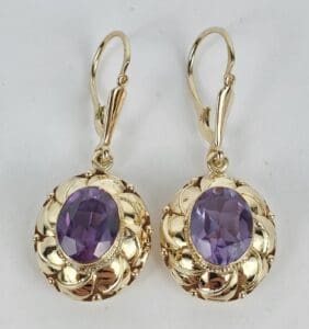 Gold earrings with purple gemstones.