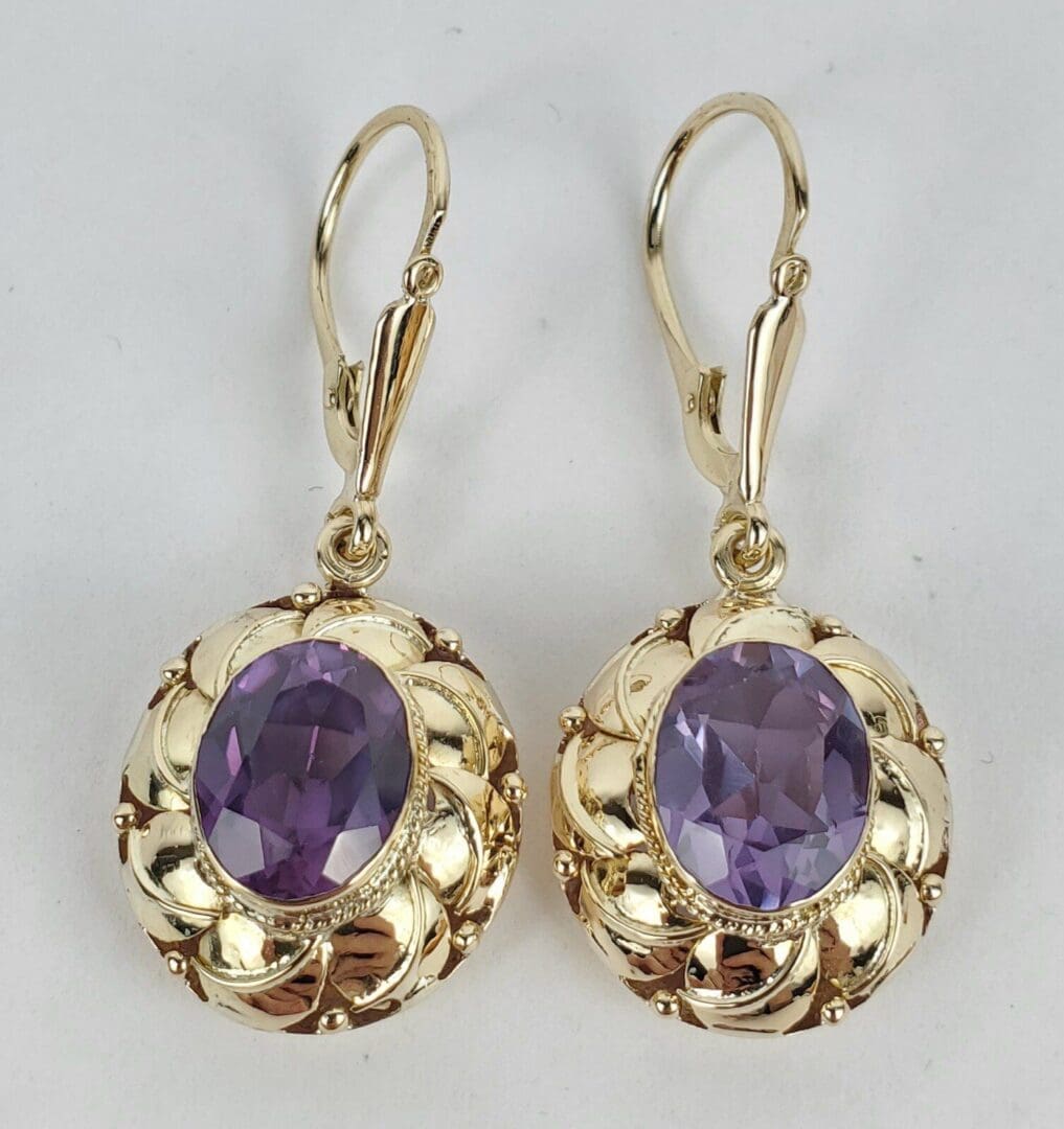 Gold earrings with purple gemstones.