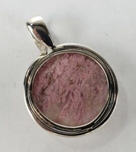 Silver pendant with round pink stone.