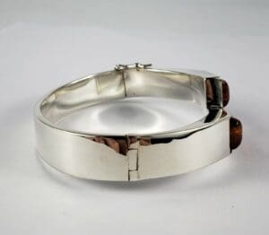 Silver bracelet with brown gemstone details.