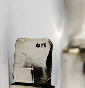 Silver object with "925" stamp close-up.