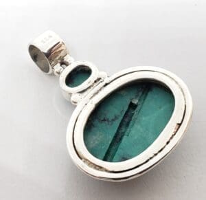 Silver pendant with oval turquoise stone.