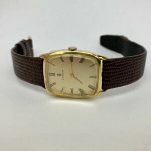 Gold wristwatch with brown leather strap.