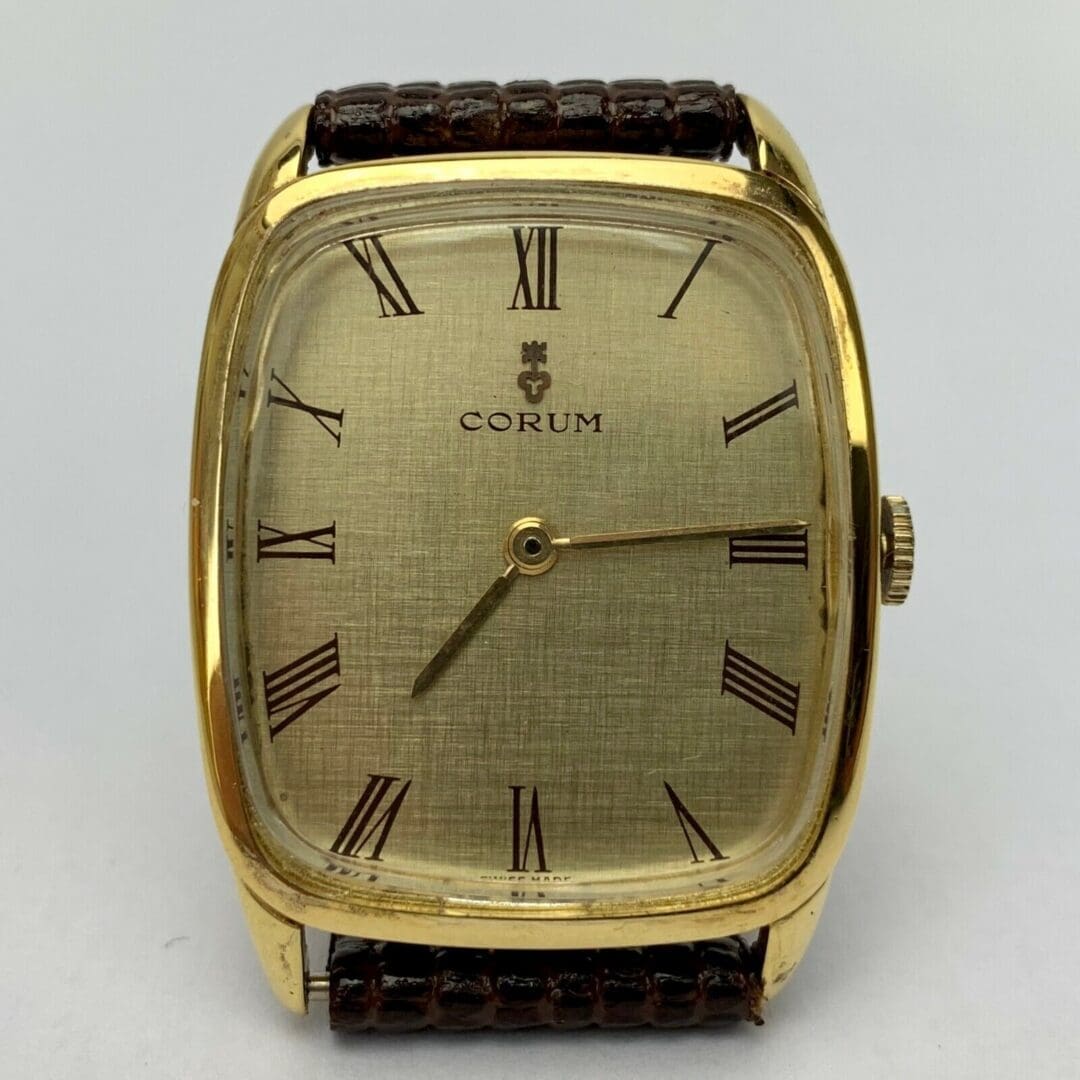 Gold watch with Roman numeral dial.