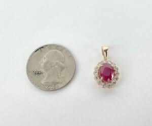 Quarter next to ruby and diamond pendant.