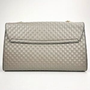 Gray quilted handbag with textured pattern.