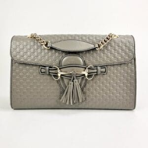Quilted gray handbag with tassel accents.