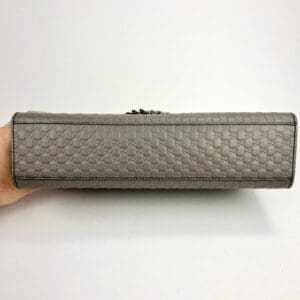 Beige textured handbag displayed horizontally.