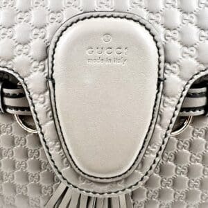 White Gucci leather bag with embossed pattern.