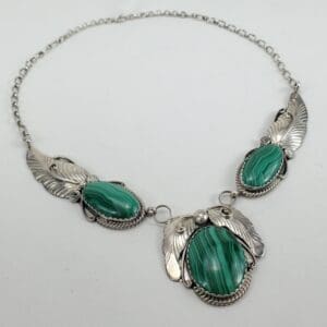 Silver necklace with green stone accents.
