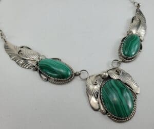 Silver necklace with green stone embellishments.
