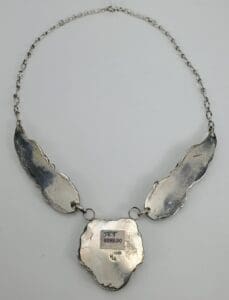 Silver necklace with three abstract shapes.