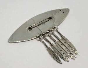 Silver brooch with hanging feather charms.