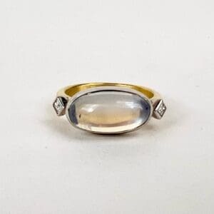 Gold ring with oval gemstone centerpiece.