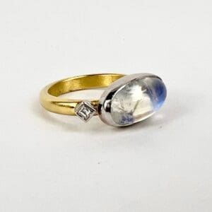 Gold ring with moonstone and diamond accent.