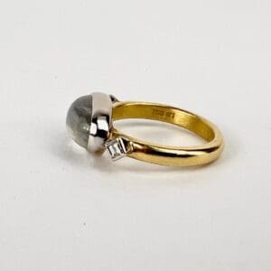 Gold ring with gemstone and diamond accent.