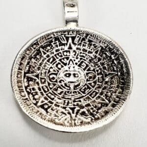 Silver pendant with intricate circular design.