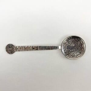 Decorative silver spoon with intricate engravings.