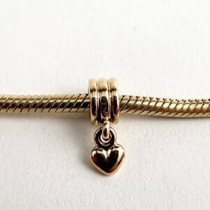 Gold bracelet with heart-shaped charm.