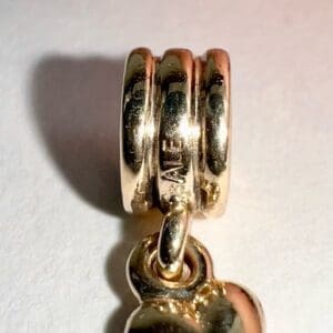 Gold charm with engraved detail close-up.