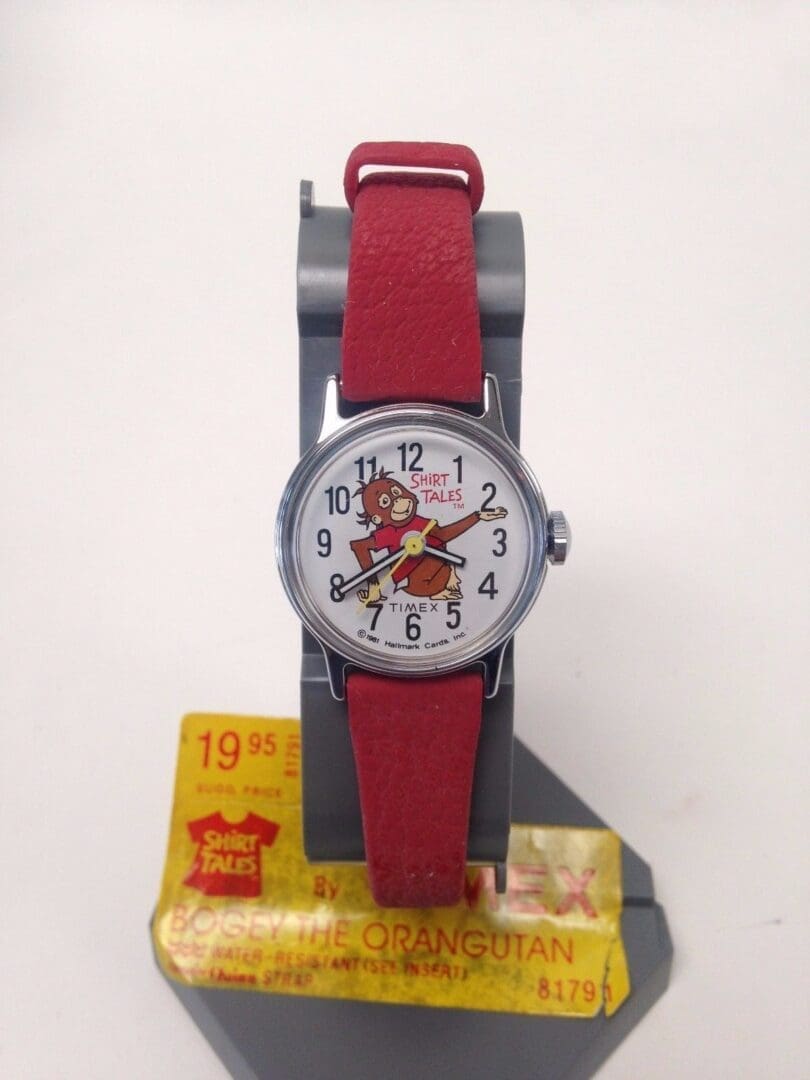 Watch with red strap and cartoon dial.