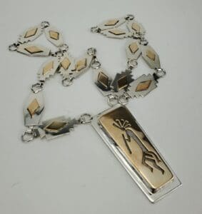 Silver and gold necklace with geometric designs.