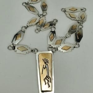 Silver necklace with geometric and figure designs.