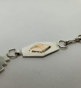 Silver bracelet with geometric design detail.