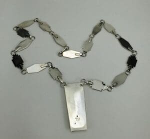Geometric metal necklace on white background.