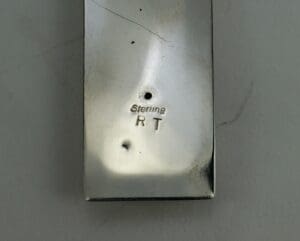 Rectangular metal object with "Sterling RT" engraving.