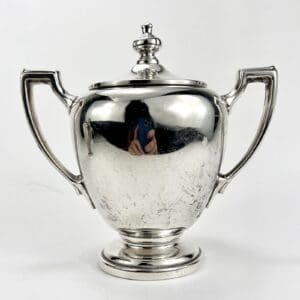 Silver trophy with two handles and lid.