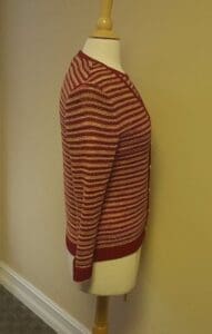 Striped sweater on a mannequin, side view.