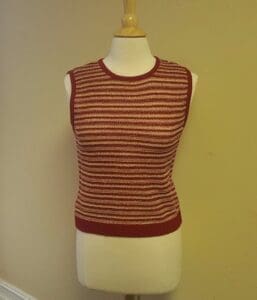 Red striped sleeveless sweater on mannequin.