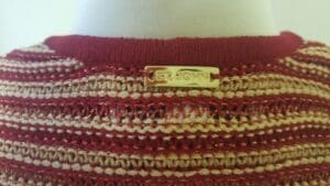 Striped sweater with gold label on mannequin.