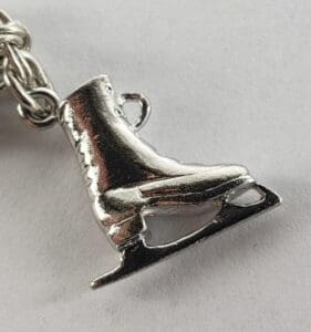 Silver ice skate charm on chain bracelet.