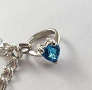 Heart-shaped blue gemstone on silver chain.
