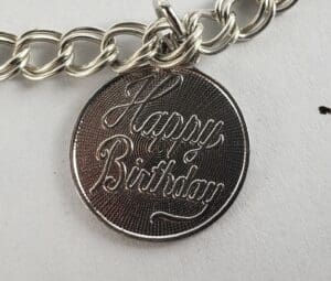 Happy Birthday" engraved silver pendant bracelet.