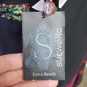 Tag with intricate design and "Extra Beads".