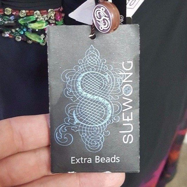Tag with intricate design and "Extra Beads".