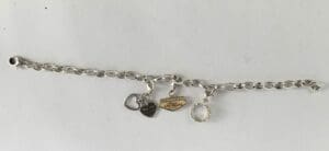 Silver charm bracelet with three dangling charms.